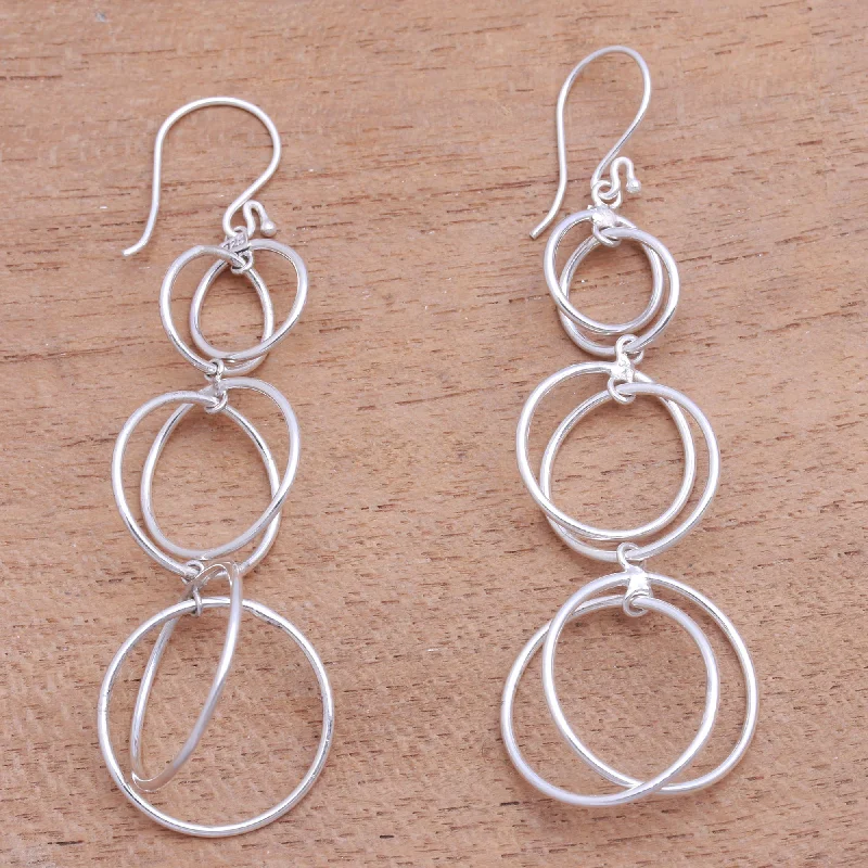 Hoop earrings with diamond-cut surfaces for added sparkle and shine-Interlocking Orbits Circular Sterling Silver Dangle Earrings from Bali